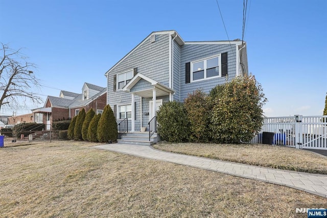 view of front of property featuring a gate, fence, and a front lawn