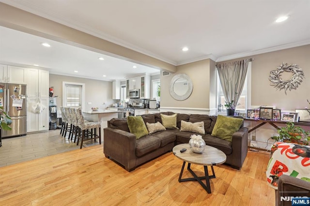 living room featuring ornamental molding, light wood finished floors, and recessed lighting