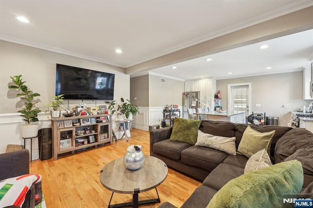 living area featuring light wood-style floors, recessed lighting, ornamental molding, and wainscoting