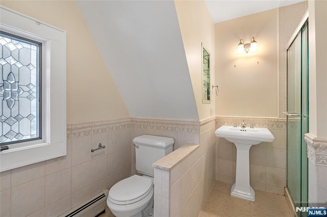 full bath with toilet, a shower stall, baseboard heating, and tile patterned floors