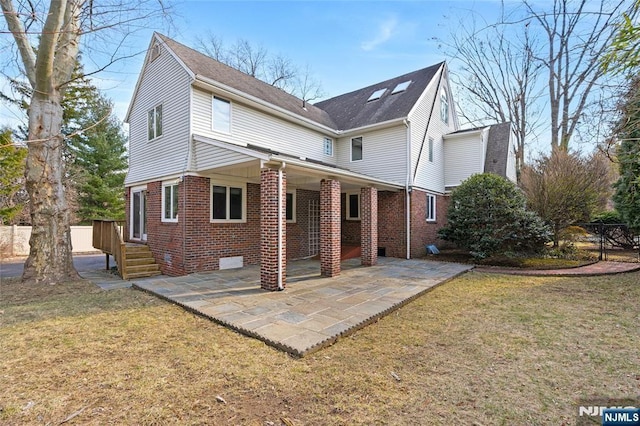 back of house with a yard, a patio area, and brick siding