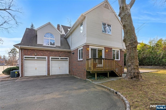 view of front of property with driveway, cooling unit, and brick siding