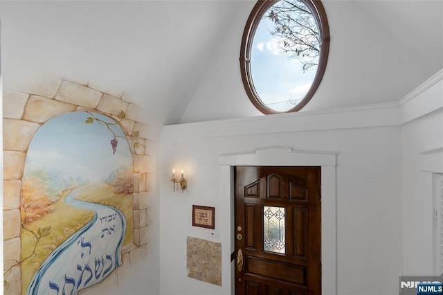 entryway with lofted ceiling and ornamental molding