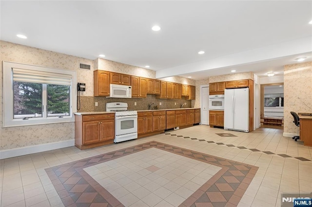 kitchen with recessed lighting, light tile patterned flooring, white appliances, baseboards, and wallpapered walls