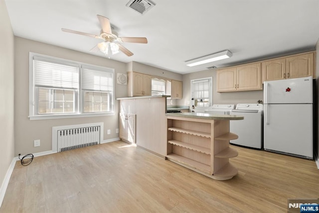 kitchen with visible vents, independent washer and dryer, light brown cabinetry, radiator heating unit, and freestanding refrigerator