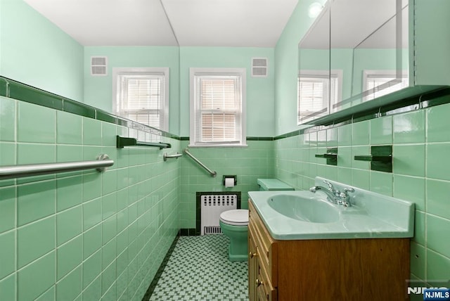 bathroom featuring visible vents, radiator, toilet, and vanity