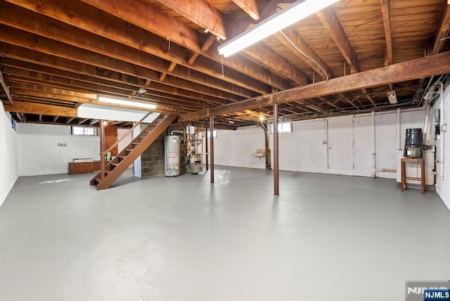 basement featuring stairs, gas water heater, and a heating unit