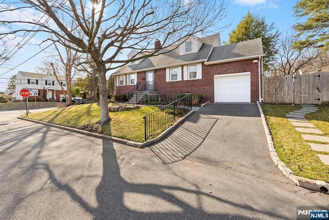 new england style home with brick siding, an attached garage, fence, a residential view, and driveway