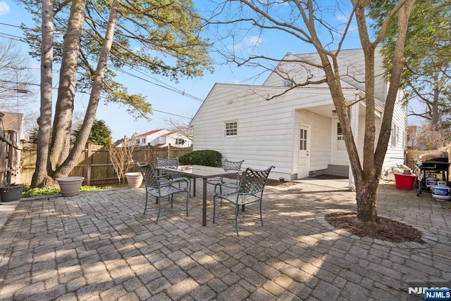 view of patio with outdoor dining space and fence