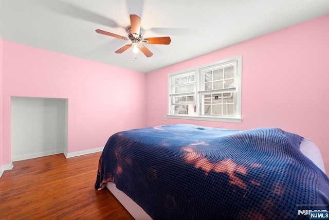 bedroom featuring a ceiling fan, wood finished floors, and baseboards