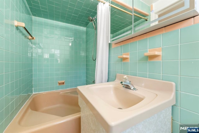 bathroom with shower / bath combo with shower curtain and tile walls