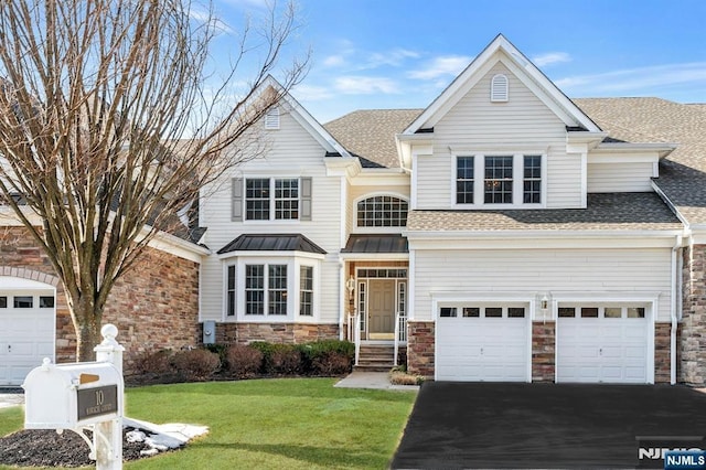 traditional-style home featuring aphalt driveway, a front lawn, and a shingled roof