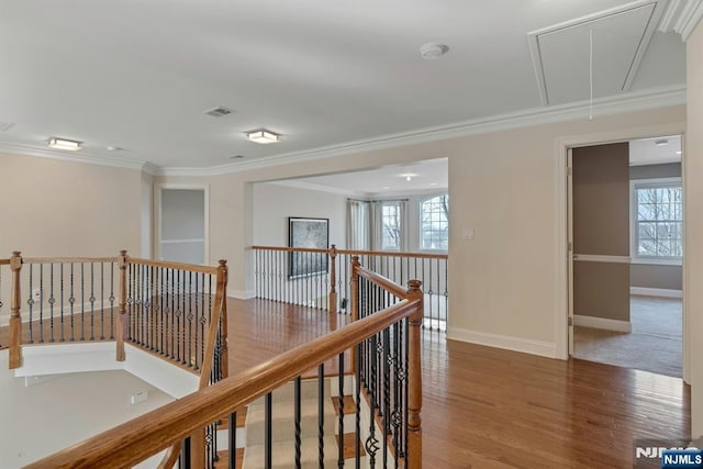 hall with attic access, ornamental molding, and an upstairs landing