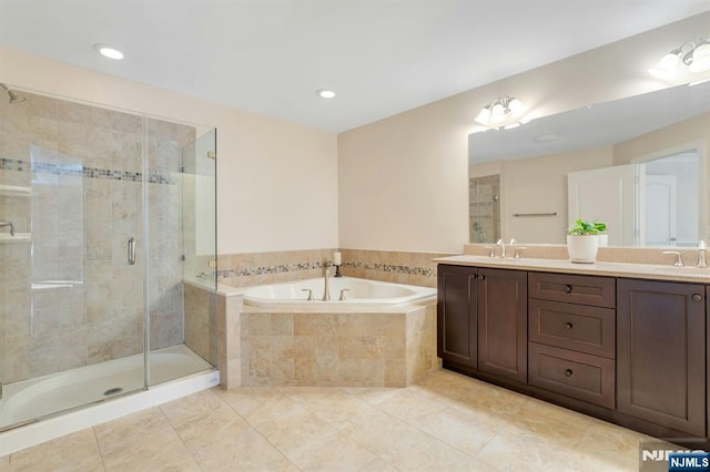 full bathroom featuring a stall shower, double vanity, a sink, and a bath