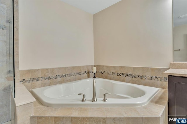 full bathroom with vanity and a bath