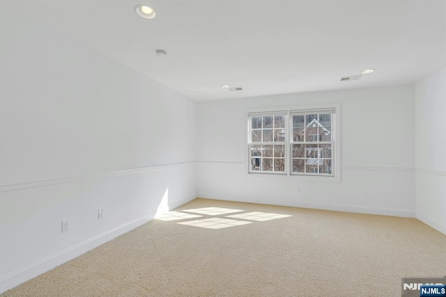 carpeted spare room featuring recessed lighting, visible vents, and baseboards