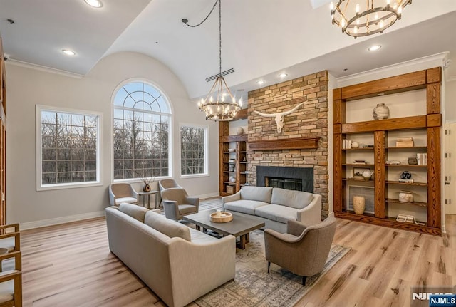 living area featuring built in shelves, light wood-type flooring, vaulted ceiling, and baseboards