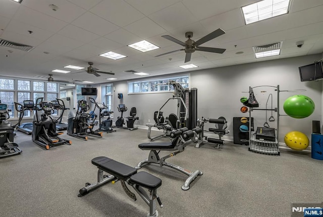 exercise room featuring a paneled ceiling, visible vents, and baseboards