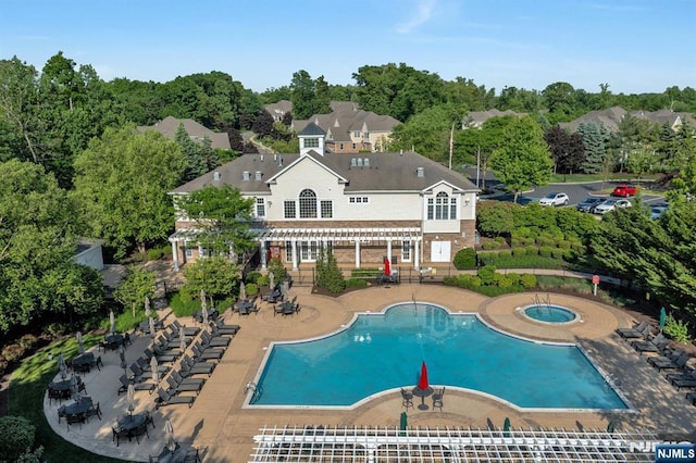 back of house featuring a patio, a community pool, a residential view, a pergola, and a hot tub