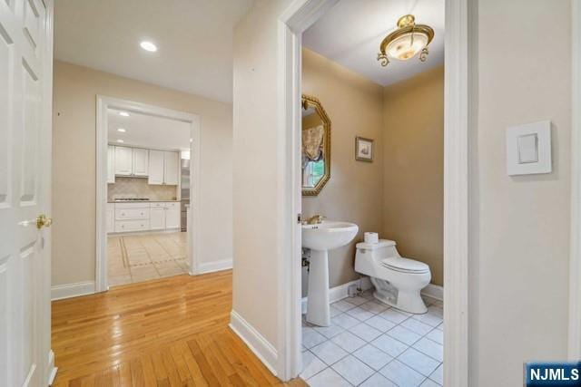 half bathroom with tasteful backsplash, baseboards, toilet, tile patterned flooring, and recessed lighting