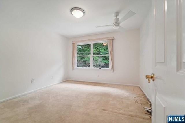 carpeted empty room with ceiling fan and baseboards