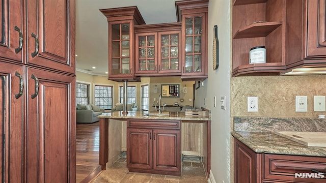 kitchen with light stone countertops, tasteful backsplash, ornamental molding, and open shelves