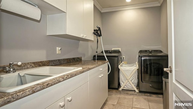 washroom with light tile patterned floors, cabinet space, ornamental molding, a sink, and separate washer and dryer