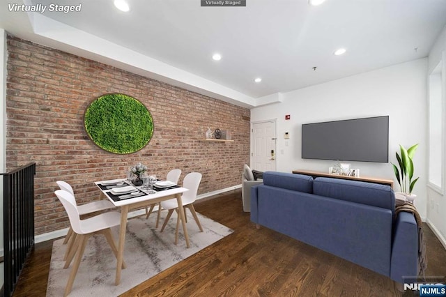 living room with brick wall, baseboards, wood finished floors, and recessed lighting