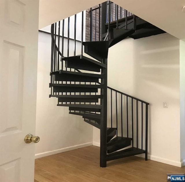 staircase with baseboards and wood finished floors