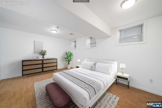 bedroom featuring baseboards and wood finished floors