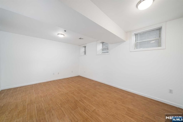 finished basement with light wood-type flooring and baseboards