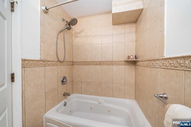 full bathroom with a combined bath / shower with jetted tub and tile walls