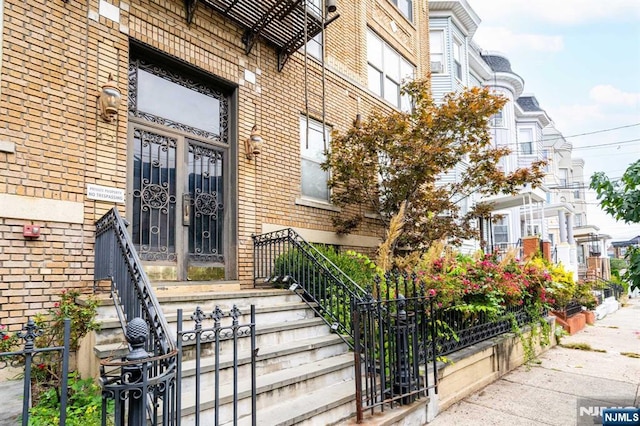 entrance to property featuring brick siding