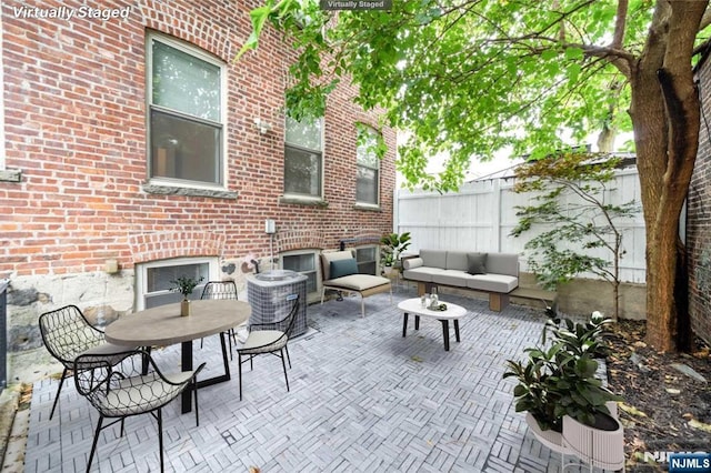 view of patio featuring outdoor dining area, fence, and an outdoor living space