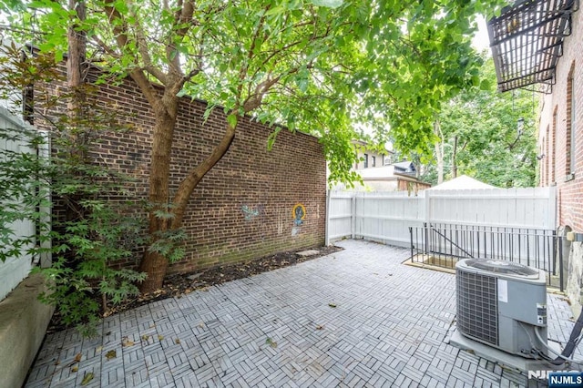 view of patio with central AC unit and fence