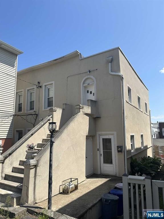 exterior space featuring stairway and stucco siding