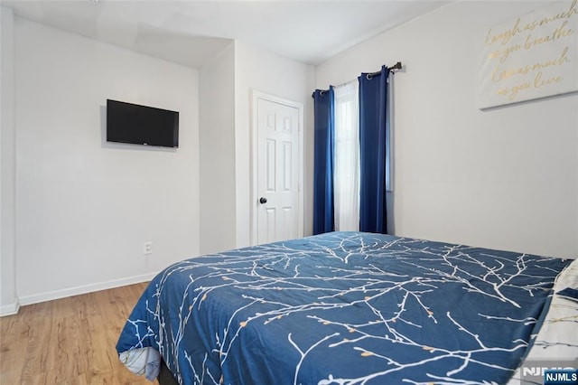 bedroom with wood finished floors and baseboards