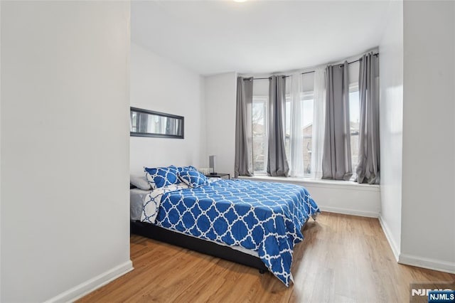 bedroom with baseboards and wood finished floors