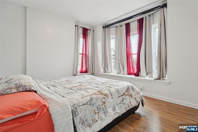 bedroom with baseboards and wood finished floors