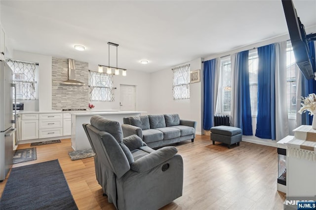 living room featuring light wood finished floors, baseboards, and a wealth of natural light