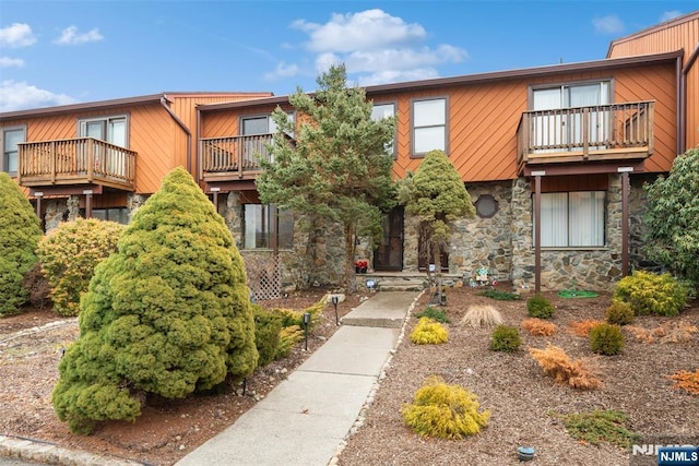 view of front of home with a balcony and stone siding