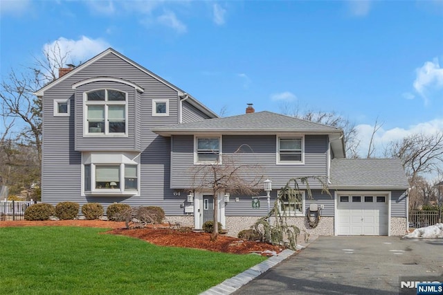 view of front of home with a garage, a shingled roof, a chimney, and a front yard