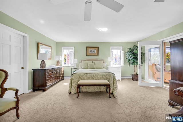 bedroom featuring light carpet, multiple windows, baseboards, and a ceiling fan