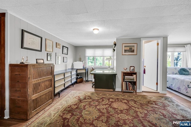 bedroom featuring ornamental molding and wood finished floors