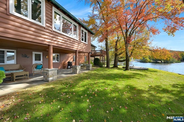 view of yard featuring a water view, a patio area, and an outdoor living space