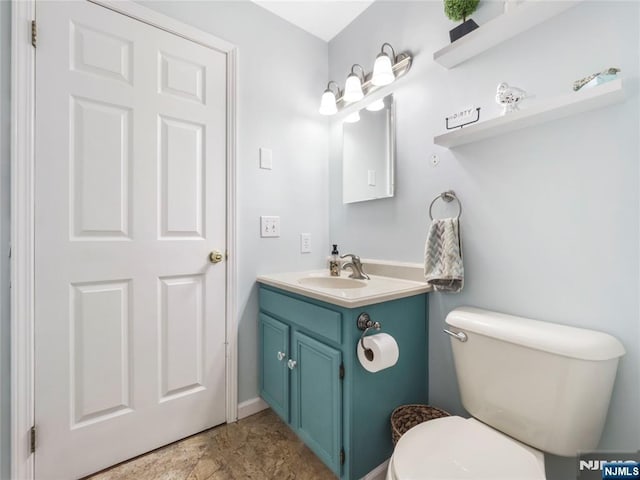 half bathroom featuring toilet and vanity