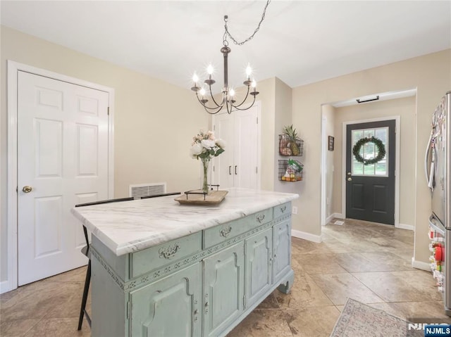 kitchen featuring a center island, decorative light fixtures, a breakfast bar area, visible vents, and light countertops