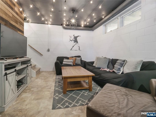 living area with stairway and concrete block wall