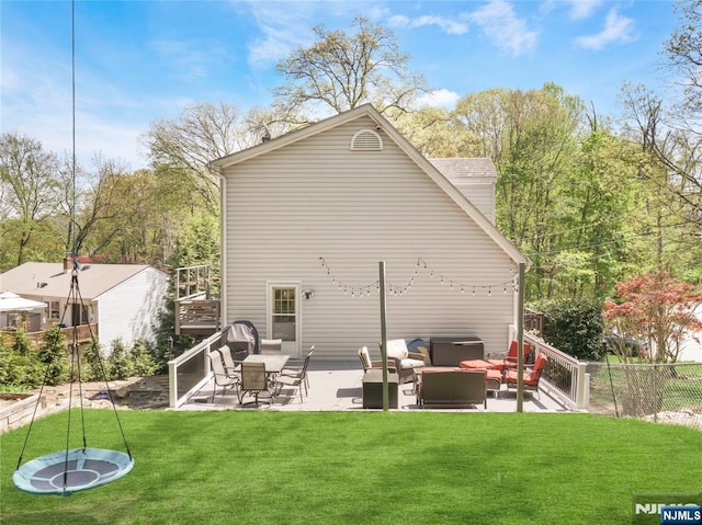 rear view of property featuring a yard, a patio, fence, and an outdoor living space