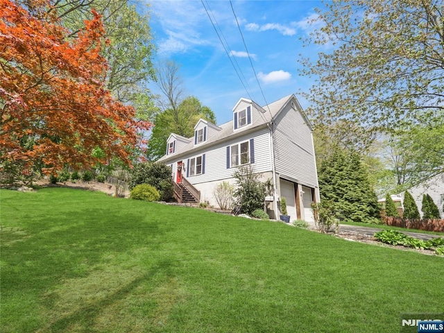 view of side of home with a yard, an attached garage, and stairs